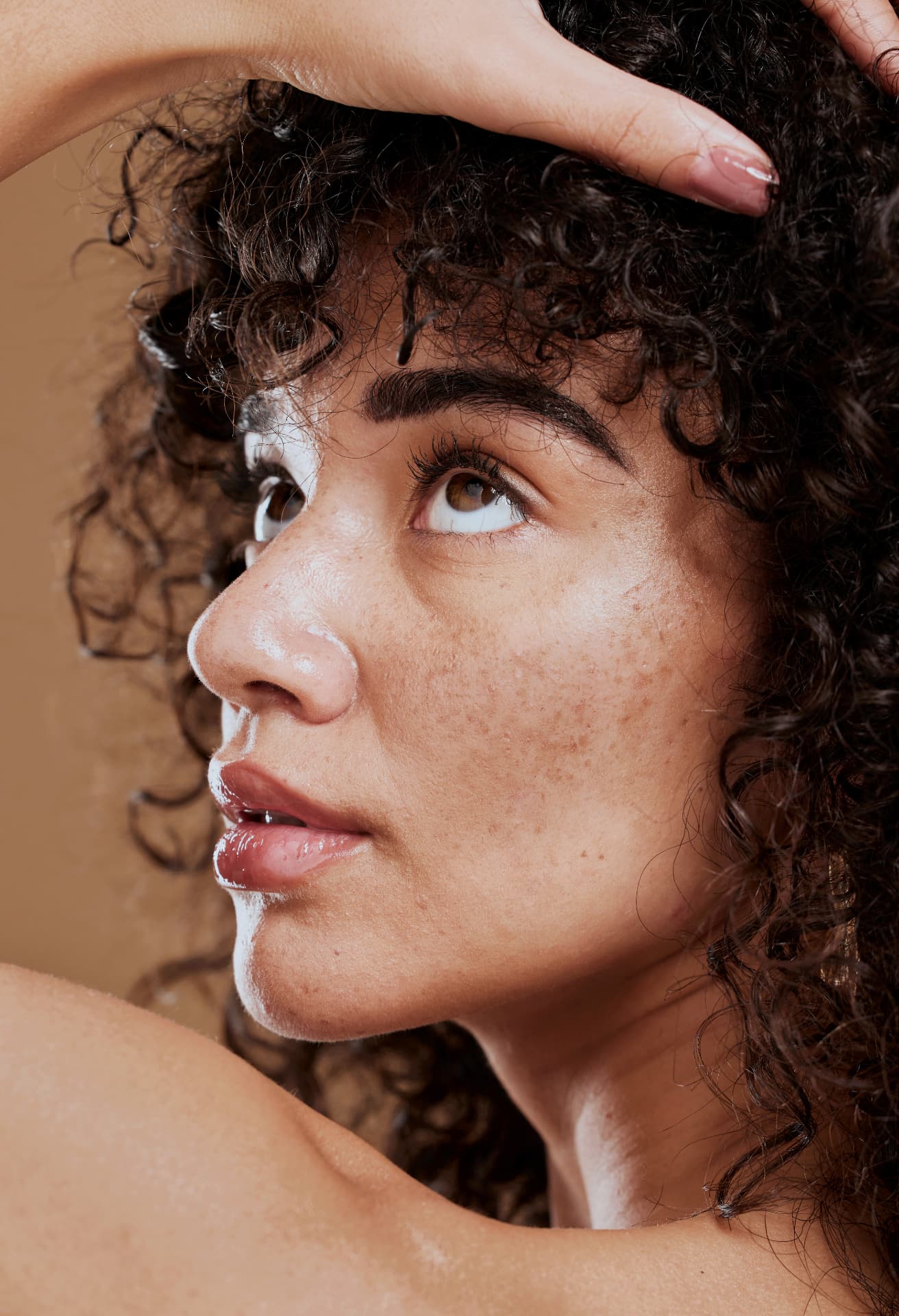 Close-up of a woman with freckled, sun-marked skin looking upward